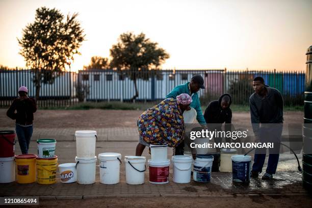 Residents of Lawley, Johannesburg, on April 24, 2020 queue to fetch water from a tank installed by the municipality to help them cope with water...