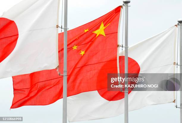The Chinese flag and Japanese flags are displayed for the arrival of China's Vice President Xi Jinping stream at Tokyo's Haneda airport on December...