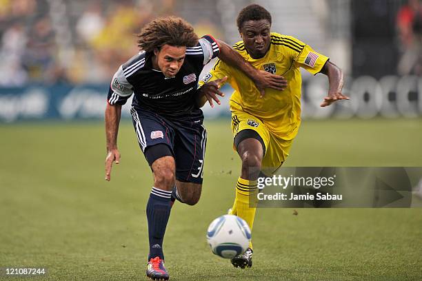 Kevin Alston of the New England Revolution and Emmanuel Ekpo of the Columbus Crew battle for control of the ball in the first half on August 13, 2011...