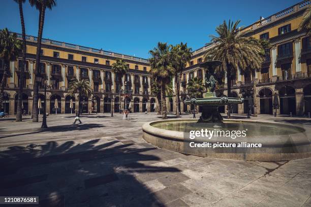 April 2020, Spain, Barcelona: Hardly anyone walks over the "Placa Real" in the famous gothic quarter in the middle of the Corona crisis. The streets...