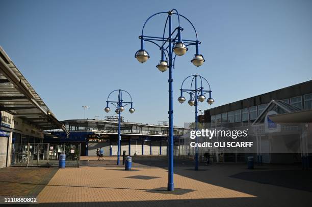 People walk in a closed Bury Market, in the town of Bury, Greater Manchester, northwest England, on April 24 2020 as life continues in Britain under...