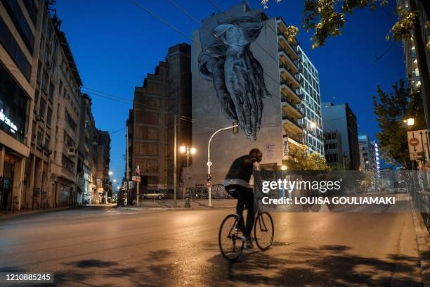 Man rides past deserted streets in central Athens on April 24 , 2020 amid the contry's lockdown to stem the spread of the COVID-19 outbreak caused by...