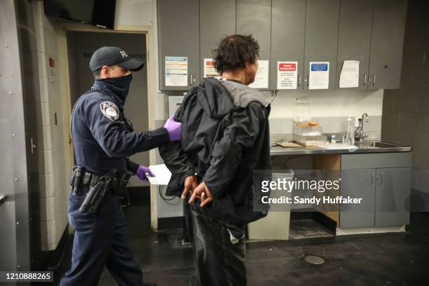 An El Cajon Police officer books a man into the San Diego County Jail on April 24, 2020 in San Diego, California. The inmates, who are trained by...