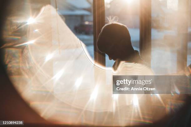 silhouette of glowing boy in front of window - children playing silhouette stock pictures, royalty-free photos & images