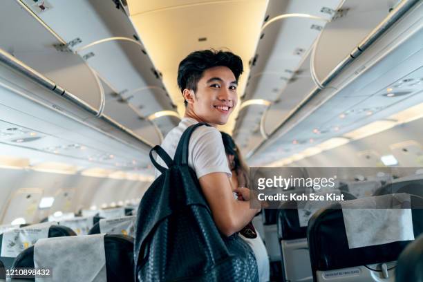 retrato de jovem viajante asiático a bordo de um avião - embarcando - fotografias e filmes do acervo