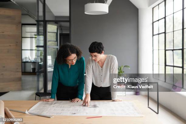 businesswomen working at table in office - business plan photos et images de collection