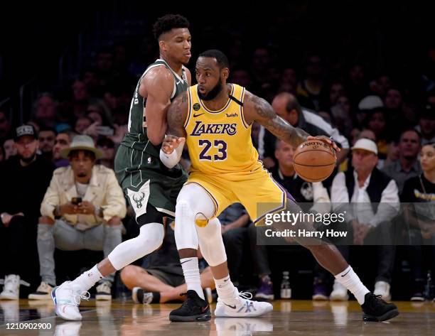 LeBron James of the Los Angeles Lakers backs in on Giannis Antetokounmpo of the Milwaukee Bucks during the third quarter at Staples Center on March...