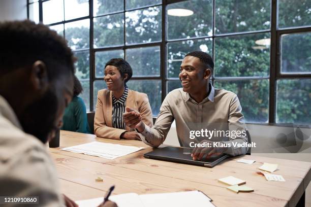 smiling colleagues in conference room at workplace - colleagues in discussion in office conference room stockfoto's en -beelden