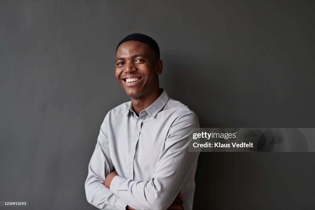 Portrait of businessman against wall at workplace