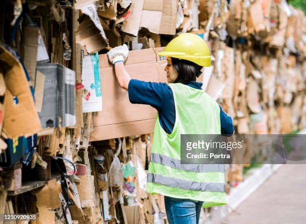vrouwelijke arbeider die bij recyclingcentrum werkt - recycling center stockfoto's en -beelden