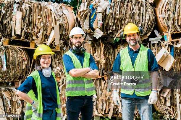 trabajadores seguros en el centro de reciclaje de cartón - recycling center fotografías e imágenes de stock