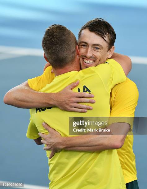 John Millman of Australia celebrates winning the match hugs Lleyton Hewitt captain of Australia during the Davis Cup Qualifier singles match between...