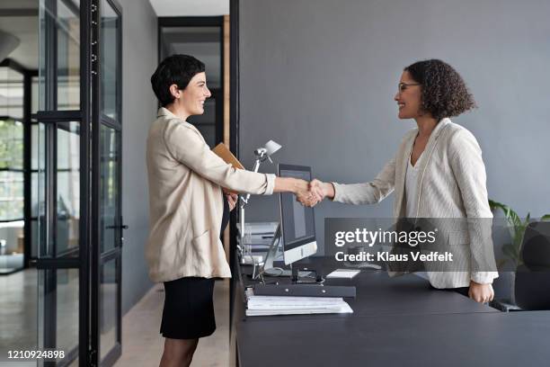 businesswomen shaking hands in modern office - interview fotografías e imágenes de stock