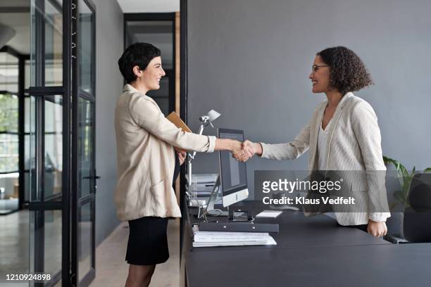 businesswomen shaking hands in modern office - interview stock pictures, royalty-free photos & images