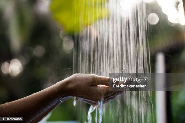 close up of unrecognizable woman holding her hands under the shower in nature. - shower stock pictures, royalty-free photos & images