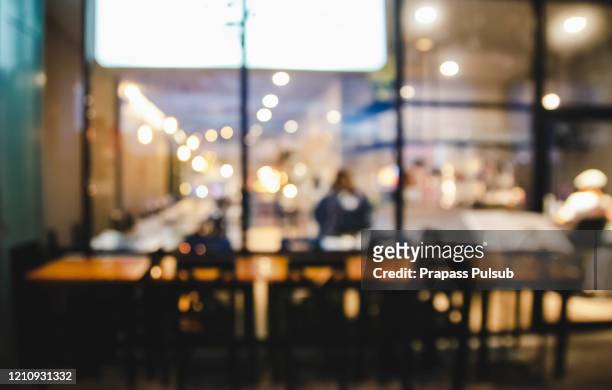 table in blur pub or bar and restaurant at night party with bokeh light background - inside coffe store stock-fotos und bilder