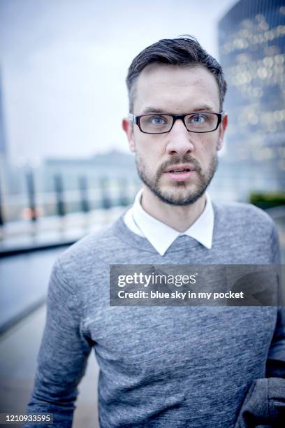 a smart casual business man looking directly at the camera, wearing eyeglasses in the rain - casual menswear stock pictures, royalty-free photos & images