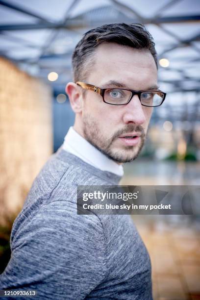 a smart casual business man looking directly at the camera, wearing eyeglasses in the rain - casual menswear stock pictures, royalty-free photos & images