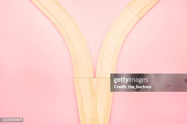 high angle view of wooden railroad tracks on pink background - intersection stock pictures, royalty-free photos & images