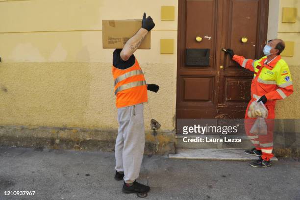 Men SVS Pubblica Assistenza volunteers deliver solidarity food shopping bags for the coronavirus emergency on April 24, 2020 in Livorno, Italy. Italy...