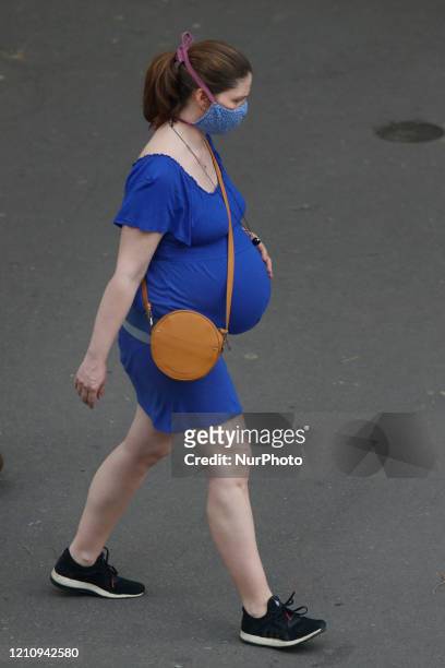 Pregnant woman walks in the street in Paris, on April 24, 2020 in Paris, France. The Coronavirus pandemic has spread to many countries across the...