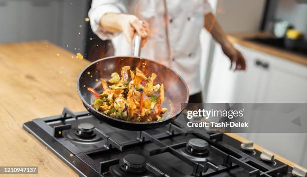 professionele chef-kok tossing food - wok stockfoto's en -beelden