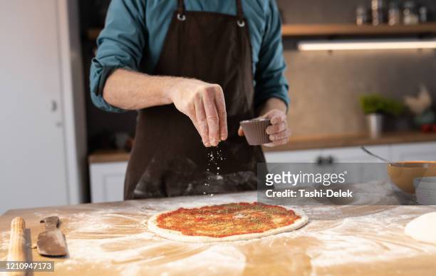 pizza wird zubereitet - sprinkles stock-fotos und bilder