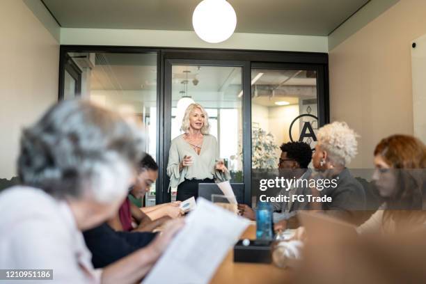 geschäftsfrau im gespräch mit ihren kollegen bei der präsentation im büro - work gender equality stock-fotos und bilder