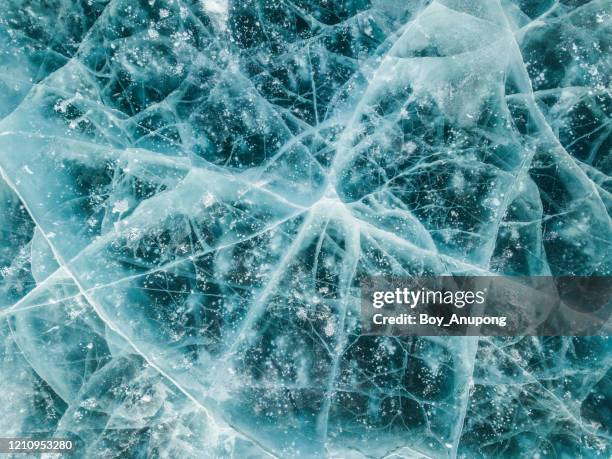 beautiful cracks surface of the frozen lake of baikal lake in winter season. - frozen lake stock pictures, royalty-free photos & images