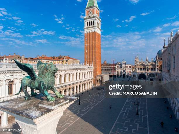 An aerial view taken on April 25, 2020 over Venice shows St. Mark's Square , the Bell Tower, the Doges Palace and the Lion of Venice ancient bronze...