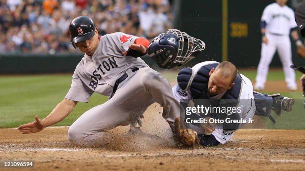 Jacoby Ellsbury of the Boston Red Sox is tagged out by catcher Josh Bard of the Seattle Mariners on a fly ball to right field by Dustin Pedroia at...