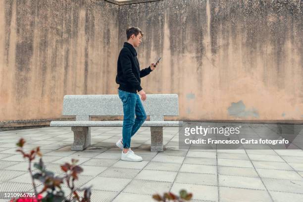 young man checks the cellphone - man side way looking imagens e fotografias de stock