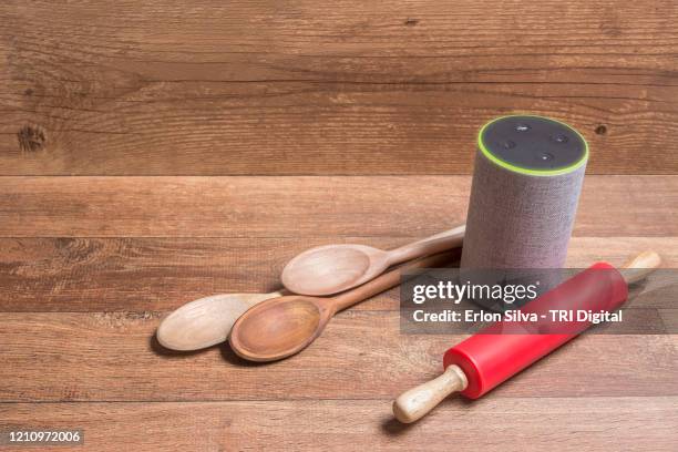 virtual assistant on a wooden background ready to assist in cooking recipes - alexa stock pictures, royalty-free photos & images
