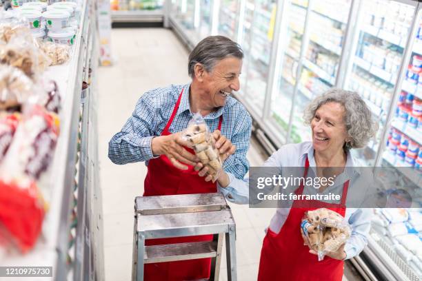 seniors working in supermarket - step stool stock pictures, royalty-free photos & images