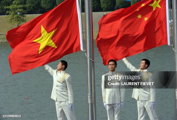 The Chinese and Vietnamese flags are raised during the medals ceremony for the lightweight women's quadruple sculls final during the 16th Asian Games...
