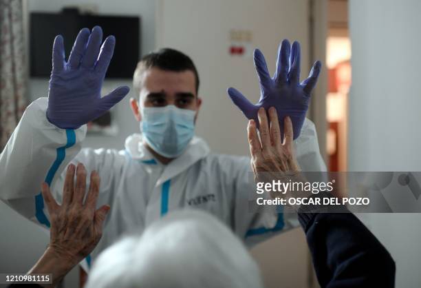 Spanish physiotherapist Vicente Barrios works out with the first coronavirus infected resident, already recovered, at an elderly people nursing home...