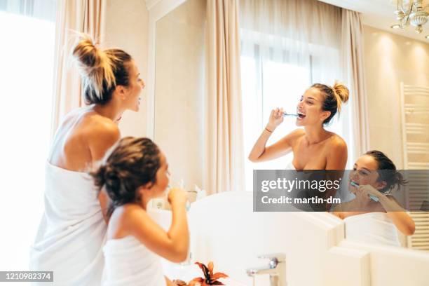 mother and daughter brushing teeth in the bathroom - hungary hotel stock pictures, royalty-free photos & images