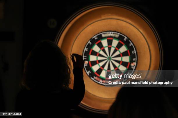 lady throwing darts - darts stockfoto's en -beelden