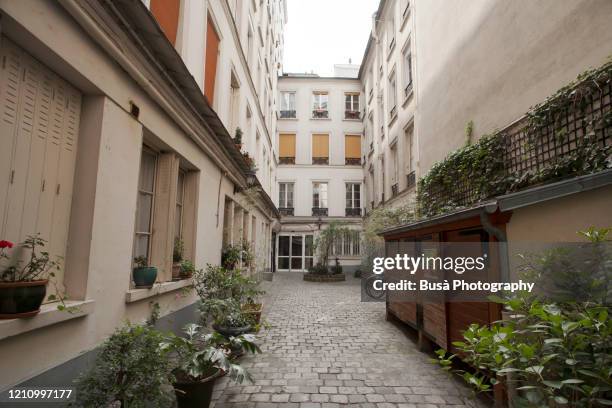 court between pre-war residential buildings in paris, france - courtyard stockfoto's en -beelden