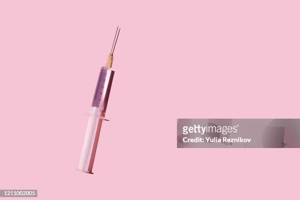 syringe on the pink background - injection stock-fotos und bilder