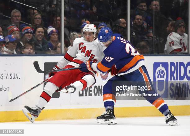Anders Lee of the New York Islanders checks Teuvo Teravainen of the Carolina Hurricanes during the first period at NYCB Live's Nassau Coliseum on...