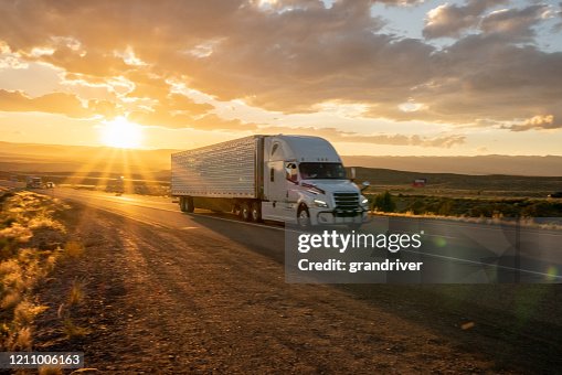 Long Haul Semi Truck Speeding Down a Four Lane Highway To Delivery Heavy Cargo Long Haul Semi Truck Speeding Down a Four Lane Highway To Delivery Heavy Cargo