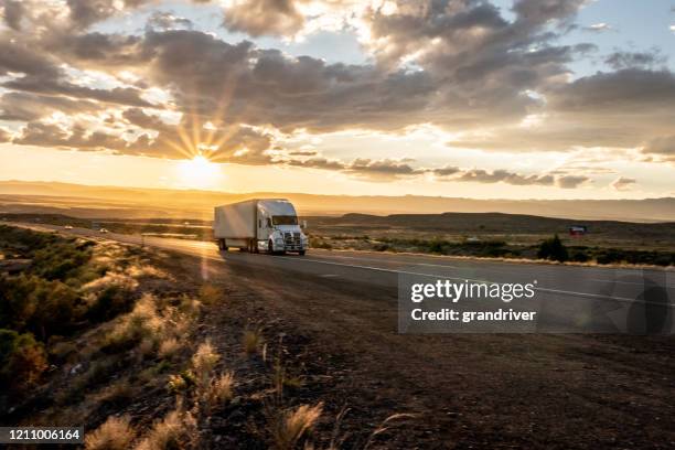 long haul semi truck speeding down a four lane highway to delivery heavy cargo - lkw reifen stock-fotos und bilder