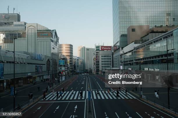 People cross a road in the Shinjuku district of Tokyo, Japan, on Saturday, April 25, 2020. Prime Minister Shinzo Abe extended an emergency...