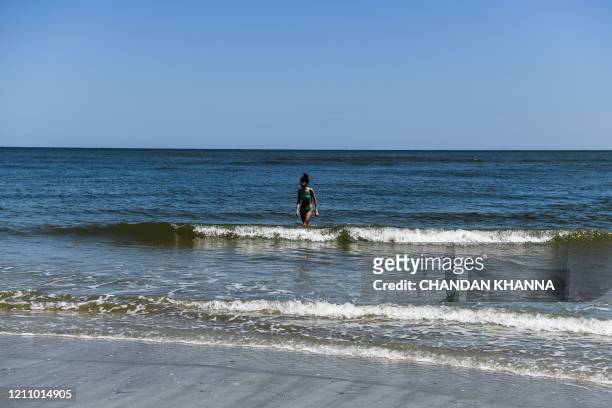 Children play with their father on the Beach amid the Coronavirus pandemic in Tybee Island, Georgia on April 25, 2020. - After being locked down for...
