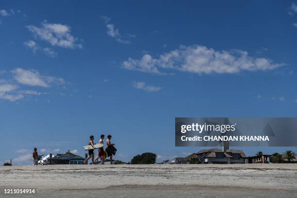 People relax on the Beach amid the Coronavirus pandemic in Tybee Island, Georgia on April 25, 2020. - After being locked down for weeks, many...