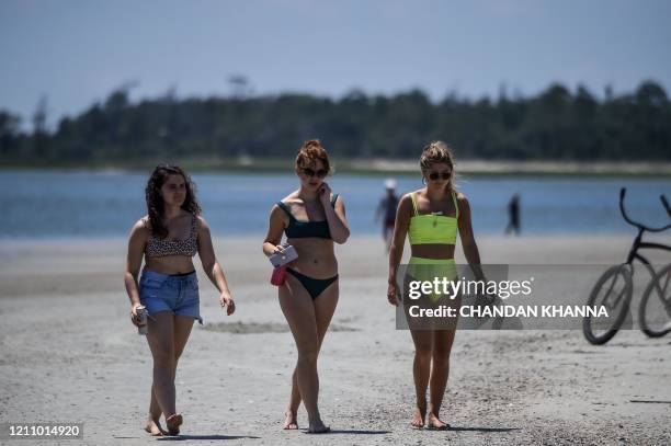 People relax on the Beach amid the Coronavirus pandemic in Tybee Island, Georgia on April 25, 2020. - After being locked down for weeks, many...