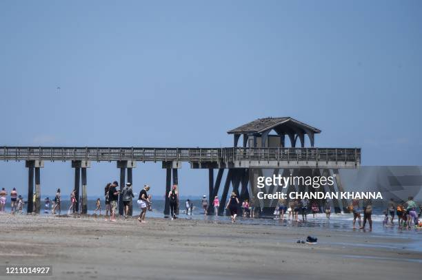 People relax on the Beach amid the Coronavirus pandemic in Tybee Island, Georgia on April 25, 2020. - After being locked down for weeks, many...