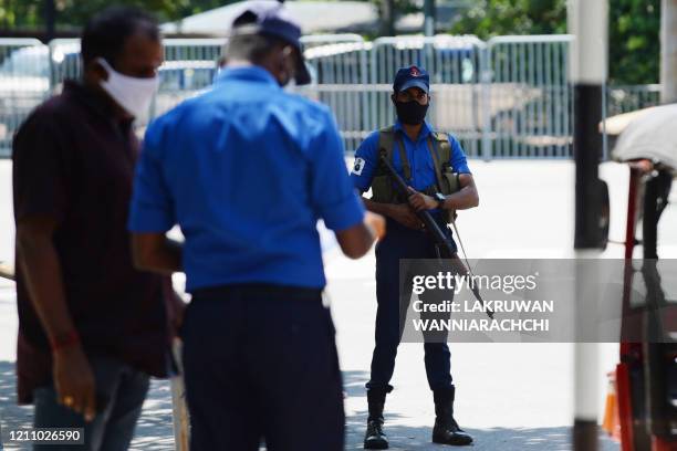 Sri Lankan Navy personnel wearing a facemask stands guard at a checkpoint during a government-imposed nationwide lockdown as a preventive measure...