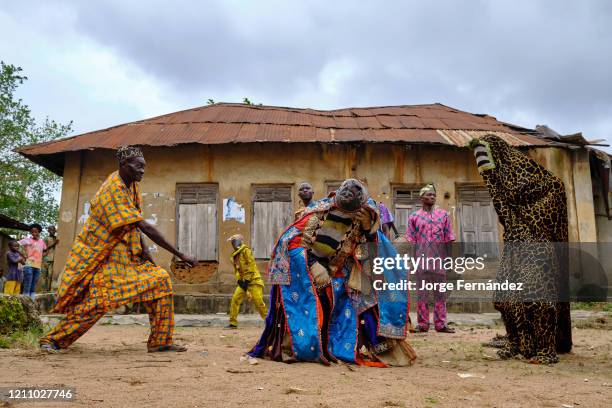 Man dressed with an Egungun mask performing during a ritual dance. The Egungun is a Yoruba character that represents the ancestors in the religious...